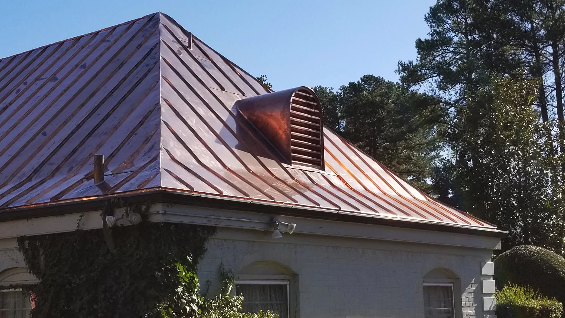 Custom made copper barrel dormer on metal roof